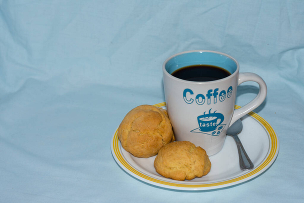 petit déjeuner avec café noir et boulettes de pain sur fond bleu - Photo, image