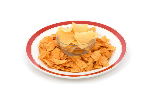 Bowl is full of tasty crispy potato chips isolated on white background. High resolution photo. Full depth of field. - Photo, Image