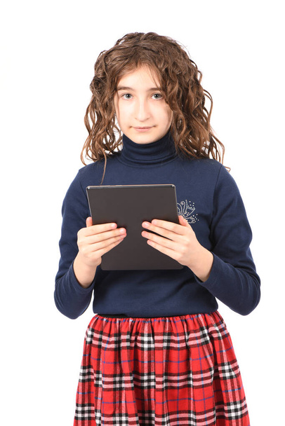 Портрет досить кучерявої молодої дівчини посміхається і показує планшетний ПК ізольовано на білому тлі. Фотографія високої роздільної здатності. Повна глибина різкості
. - Фото, зображення