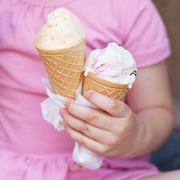 girl in pink dress eating ice cream in hot weather - 写真・画像