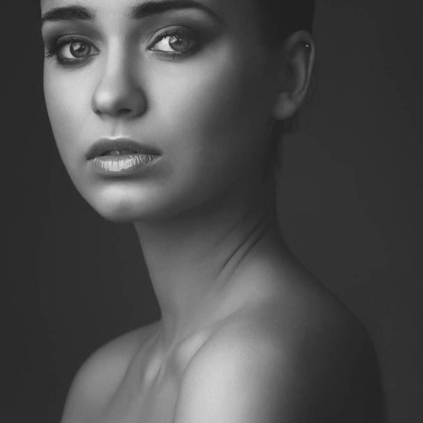 studio portrait of young beautiful girl on dark background. black and white - Valokuva, kuva