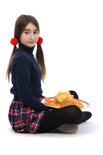 La niña preadolescente sosteniendo el plato está llena de papas fritas. Aislado sobre fondo blanco. Foto de alta resolución. Profundidad total del campo. - Foto, Imagen