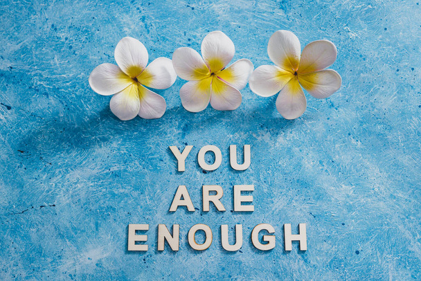 mental health and self-worth concept, You are enouugh text with flowers and blue background - 写真・画像