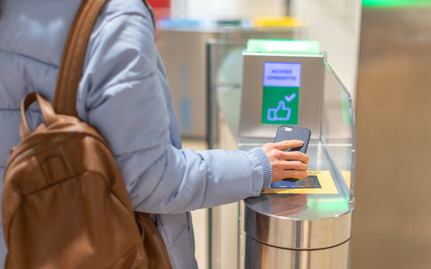 Electronic Boarding pass and passport control in the airport - hand with boarding pass on smartphone at the turnstile. - Foto, imagen