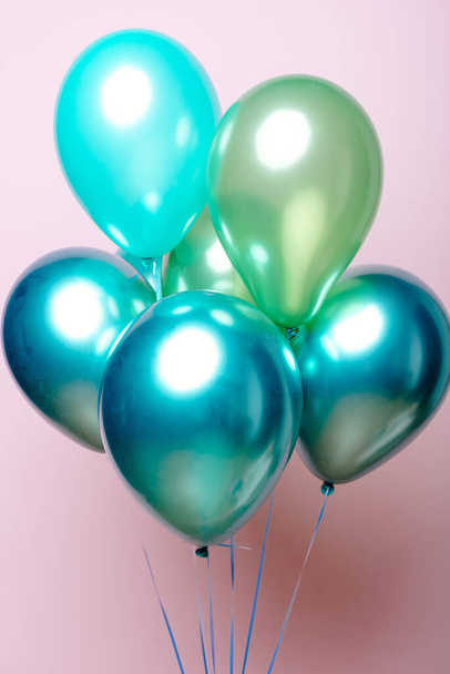 Composition of light green, green, emerald helium balloons on a pink background. - Foto, Bild