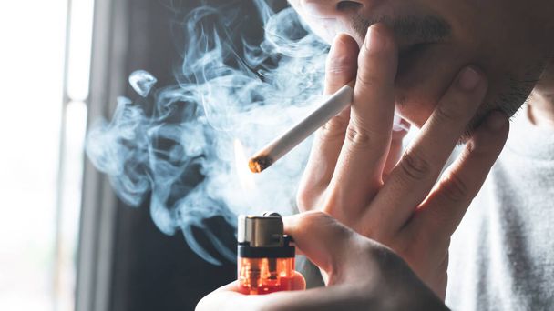 Чоловік курить сигарету вдома
 - Фото, зображення