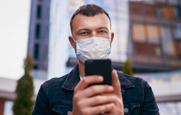 Man using smartphone during pandemic on street - Foto, Imagem