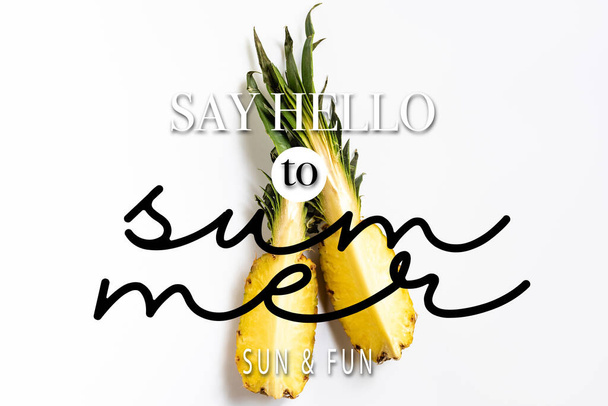 top view of cut ripe pineapple with green leaves on white background with say hello to summer illustration - Foto, Imagem