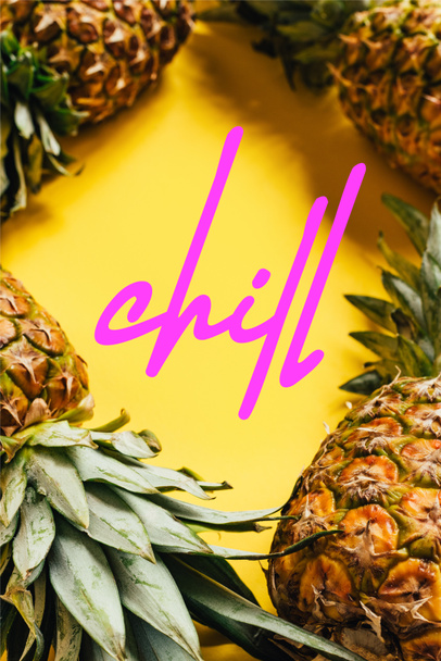 selective focus of fresh ripe pineapples with green leaves on yellow background with chill illustration  - Fotografie, Obrázek