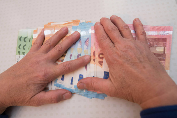hands of an old person reaching for money, finances and pension - Foto, Imagen
