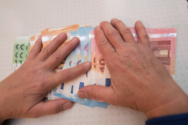 hands of an old person reaching for money, finances and pension - Фото, изображение