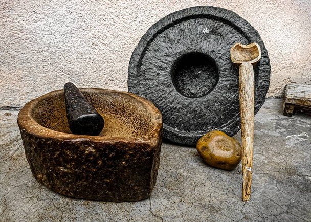 Altindische Schleif- und Zerkleinerungswerkzeuge aus Stein mit einem Holzlöffel. - Foto, Bild