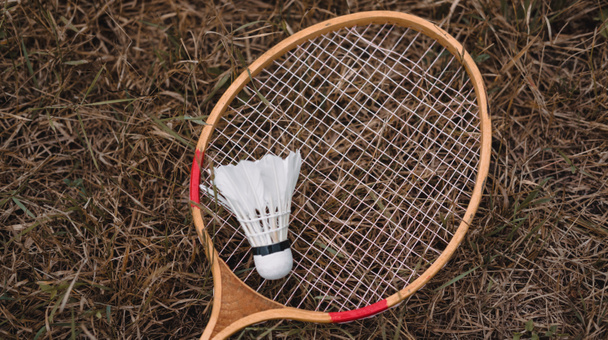 Dřevěné badmintonové rakety a bílý péřový raketoplán. Hra na badminton. Koníčky a venkovní rekreace. - Fotografie, Obrázek
