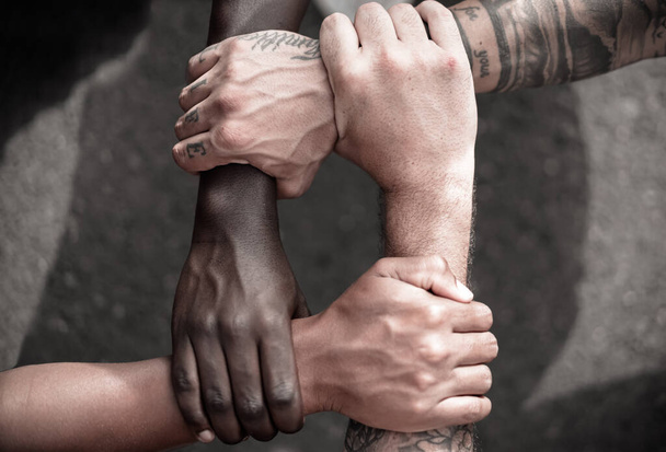 Multietničtí lidé s černýma, latinskýma, bělošskýma a asijskýma rukama, co se drží za zápěstí. tolerance, týmová práce a protirasistický koncept. Obrázek - Fotografie, Obrázek