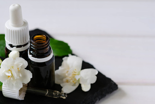 натуральный косметический продукт, жасминовое масло со стеклянными бутылками на деревянном столе
 - Фото, изображение