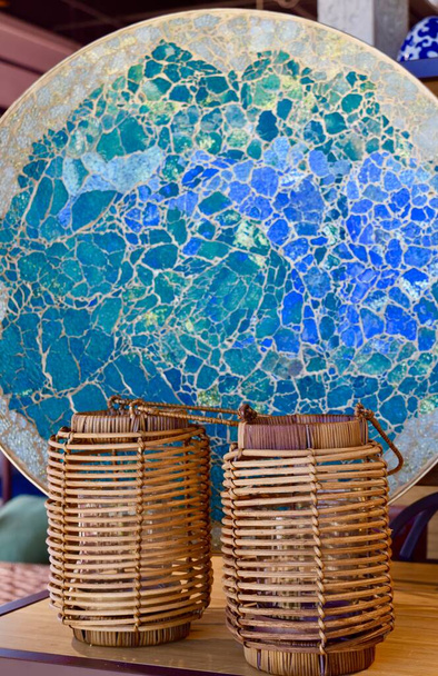 A vertical shot of a blue broken glass plate and two bamboo candle holders for interior design - Foto, afbeelding