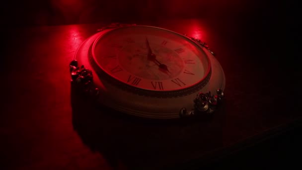 Η ιδέα του χρόνου. Μεγάλο vintage στρογγυλό ρολόι σε ξύλινο τραπέζι με αφηρημένο φως. Σκοτεινή ατμόσφαιρα. Δημιουργική διακόσμηση. Επιλεκτική εστίαση - Πλάνα, βίντεο