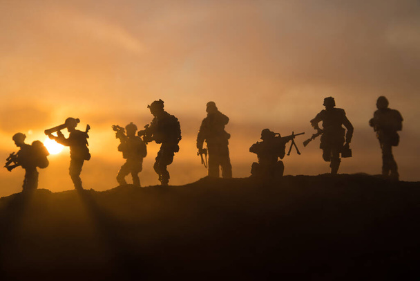 Концепция войны. Военные силуэты боевой сцены на фоне тумана на фоне неба войны, силуэт солдат мировой войны под облачным закатом. Селективный фокус - Фото, изображение