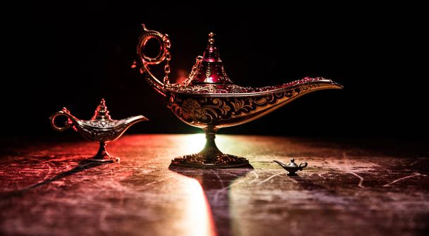 Antiguo Aladdin noches árabes lámpara de aceite de estilo genio con humo blanco claro suave, fondo oscuro. Concepto de lámpara de deseos - Foto, imagen