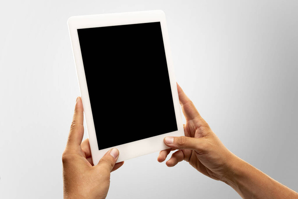 Close up male hands holding tablet with blank screen during online watching of popular sport matches and championships all around the world. Copyspace for ad - Foto, immagini