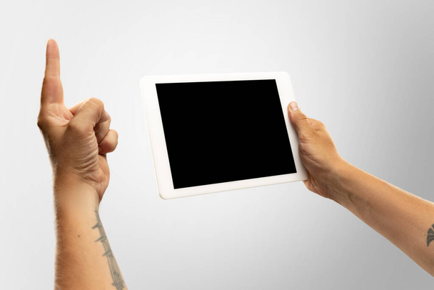 Close up male hands holding tablet with blank screen during online watching of popular sport matches and championships all around the world. Copyspace for ad - Fotografie, Obrázek