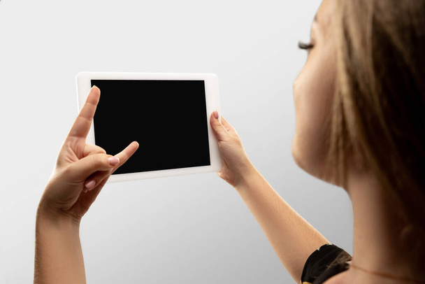 Close up female hands holding tablet with blank screen during online watching of popular sport matches and championships all around the world. Copyspace for ad - Foto, afbeelding