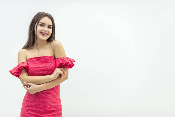 Young magnificent woman posing in trendy red dress over white background. - Фото, зображення