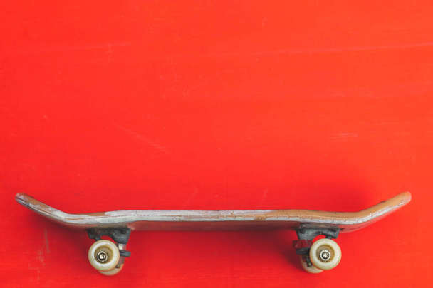Small skateboard on red background. tiny skate for fingers. fingerboard close up. copy space - Fotografie, Obrázek