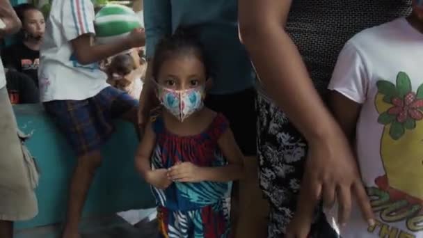 Benoa, Kuta, Kabupaten Badung, Bali, Indonesia - July 8, 2020: Video of a small village in Indonesia with masked people and children on their faces - Video