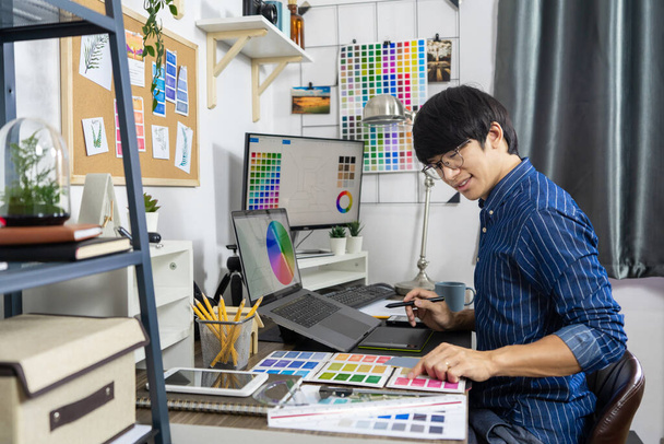 Ázsiai férfiak Építész vagy grafikus tervezése elrendezés kiválasztása swatch minták színező képernyő grafika munka felújítás, Creative Occupation Design Studio koncepció - Fotó, kép
