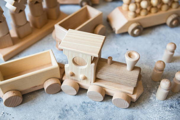 Giocattoli in legno per bambini. Treno in legno per bambini con carri e auto. Set costruzione in legno naturale. Materiale didattico. - Foto, immagini