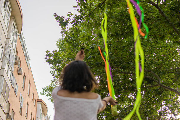 Zdjęcie młodej i atrakcyjnej kobiety grającej żonglując kolorowymi paskami - Zdjęcie, obraz