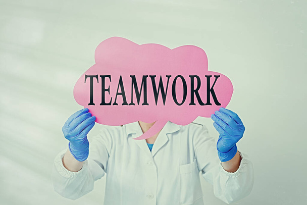 Text sign showing Teamwork. Conceptual photo the group s is collaborative effort to accomplish a common goal Laboratory technician featuring empty sticker paper accessories smartphone. - Photo, Image