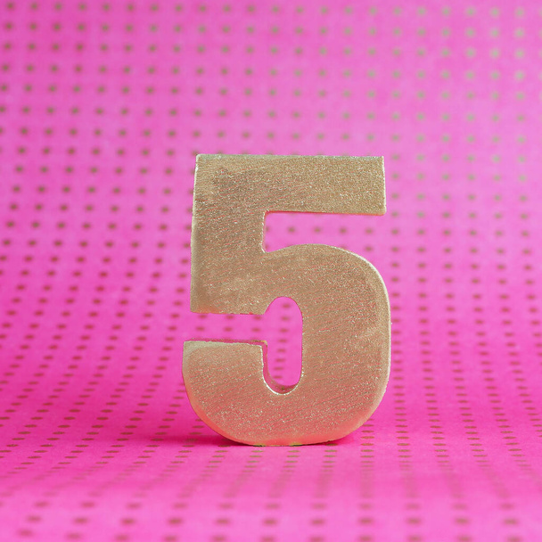 Золотой объемный номер 5 на ярко-розовом фоне в горошек. копировальное пространство
 - Фото, изображение