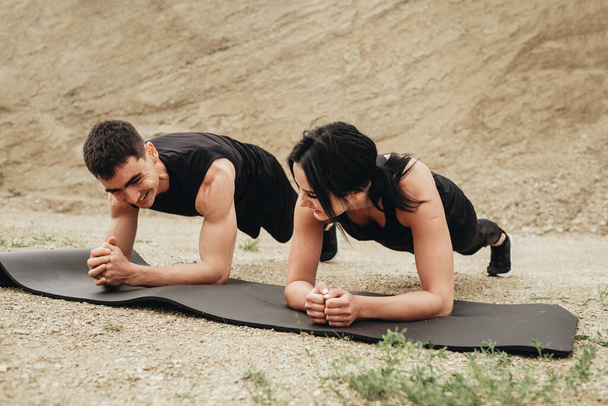 Dois atletas em Black Sportswear treinando juntos ao ar livre estilo de vida saudável e conceito de treino ao ar livre
 - Foto, Imagem