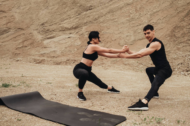 Два спортсмени в чорному спортивному одязі тренування разом відкритим небом здоровий спосіб життя та на відкритому повітрі тренувальна концепція
 - Фото, зображення