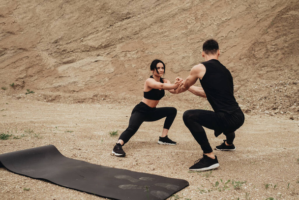 Two Athletes in Black Sportswear Training Together Open Air Healthy Lifestyle and Outdoors Workout Concept - Photo, Image