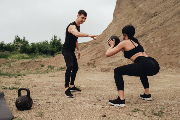 Two Athletes in Black Sportswear Training Together Open Air Healthy Lifestyle and Outdoors Workout Concept - Фото, изображение