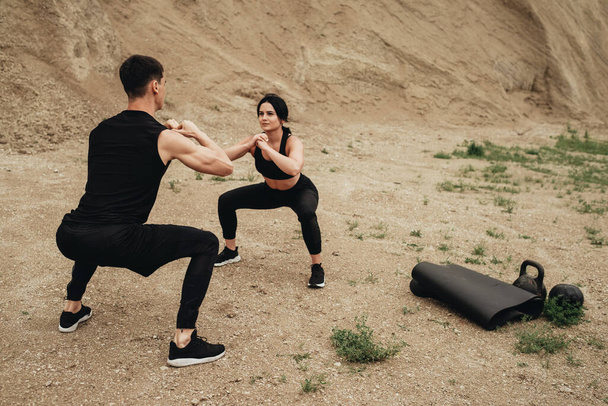 Dos atletas en ropa deportiva negra entrenando juntos al aire libre estilo de vida saludable y al aire libre concepto de entrenamiento
 - Foto, imagen