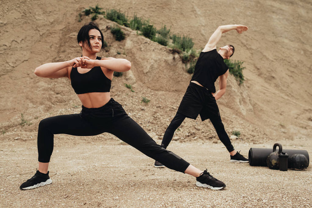 Two Athletes in Black Sportswear Training Together Open Air Healthy Lifestyle and Outdoors Workout Concept - Foto, Bild