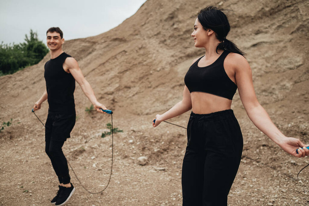 Two Athletes in Black Sportswear Training Together Open Air Healthy Lifestyle and Outdoors Workout Concept - Photo, Image