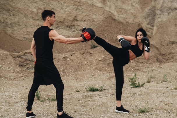 Twee boksers in zwarte sportkleding training samen open lucht gezonde Lifestyle en Outdoor Workout Concept - Foto, afbeelding