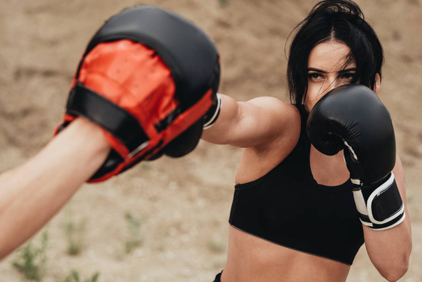 Dos boxeadores en ropa deportiva negra entrenando juntos al aire libre estilo de vida saludable y concepto de entrenamiento al aire libre
 - Foto, Imagen