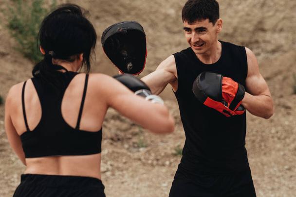 Two Boxers in Black Sportswear Training Together Open Air Healthy Lifestyle and Outdoor Workout Concept - 写真・画像