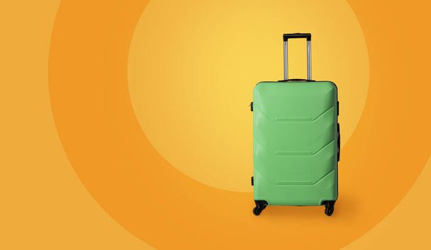 Travel luggage suitcase. Green plastic suitcase with wheels and retractable telescopic handle isolated on yellow background. Carry-on baggage. Vacation concept. Template blank for ad banner - Foto, afbeelding