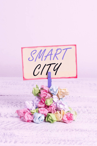 Writing note showing Smart City. Business photo showcasing an urban area that uses communication technologies to collect data Reminder pile colored crumpled paper clothespin wooden space. - Photo, image