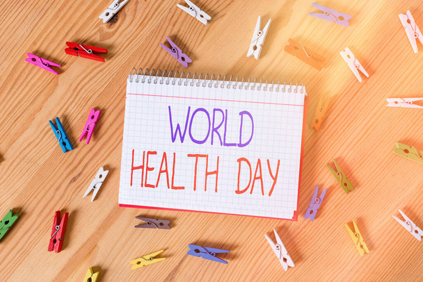 Fogalmi kézírás az Egészségügyi Világnapról. Üzleti fotó szöveg globális egészségügyi tudatosság nap ünneplik minden évben 7 Április Színes gyűrött papírok fa padló háttér ruhaszárító. - Fotó, kép