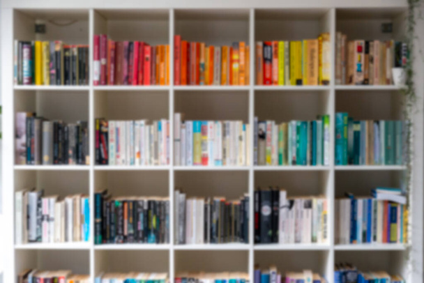 Image floue d'une bibliothèque en bois blanc remplie de livres - Photo, image
