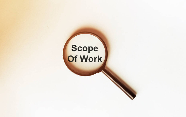 Scope Of Work on a sheet under a magnifying glass - Photo, Image