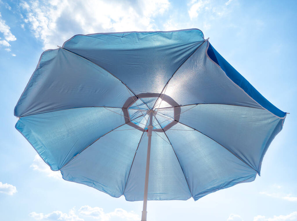 Plážový deštník. Přes deštník na pláži, sluneční paprsky pronikají skrz ně. - Fotografie, Obrázek